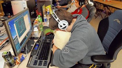 Charlie Black, of McCandless, struggles to stay awake as sunshine creeps into the windows of the Castle Shannon Volunteer Fire Department Hall Sunday morning, where he had been playing video games since 3 p.m. Saturday. At one point, 153 tournament gamers filled the hall, but fewer than 30 remained by late Sunday morning.