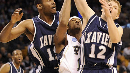 Pitt's Gilbert Brown gets caught in between Xavier's B.J. Raymond and Brad Redford in the first half of their NCAA East Regional game in Boston tonight.