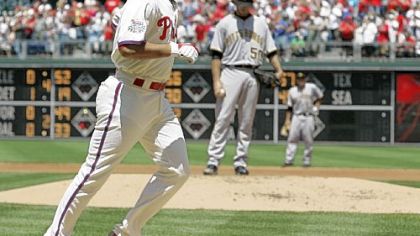 The Philadelphia Phillies' Pedro Feliz heads to home after hitting a grand slam off Pirates starter Virgil Vasquez, rear, in the first inning yesterday in Philadelphia.
