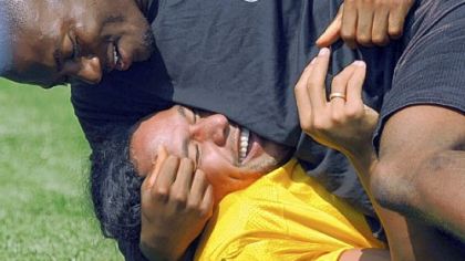 Troy Polamalu gets "help" with stretching from teammate Ryan Clark yesterday at training camp.