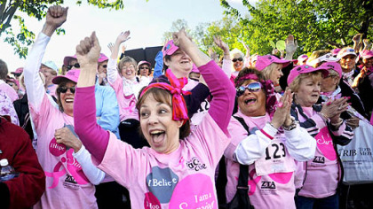 Darlene Beward of Whitehall cheers during the Survivor's Walk of the Race for the Cure in Schenley Park yesterday.  Ms. Beward is a five-year cancer survivor.