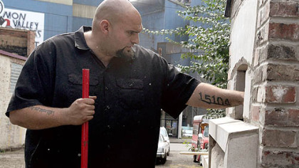 Braddock Mayor John Fetterman pokes around a community bread oven as it was being readied for a trial run in September.