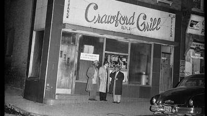 Three men standing outside of the Crawford Grill No. 1.