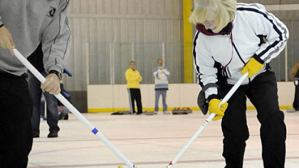 Ron Katila and Ann Byrd, both of Mt. Lebanon, brush the stone during a "learn to curl" class at the Robert Morris University Island Sports Center on Neville Island.