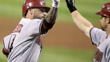 Diamondbacks infielder Ryan Roberts, left, is greeted by first baseman Chad Tracy as he returns to the dugout after hitting a home run off Pirates pitcher Ross Ohlendorf in the sixth inning.