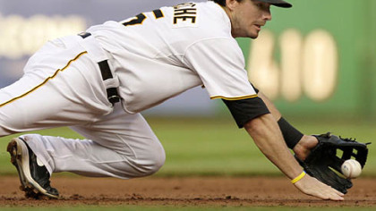 Pirates third baseman Andy LaRoche makes a diving stop on a ground ball by Diamondbacks infielder Ryan Roberts during the second inning. LaRoche recovered to make the putout on Roberts at first.