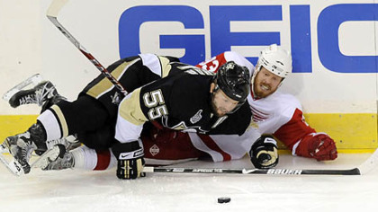 Penguins Sergei Gonchar and Red Wings Johan Franzen fight for the puck along the boards in the first period tonight at Mellon Arena.
