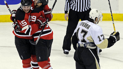 Petr Sykora heads off the ice as Jamie Langenbrunner, left, celebrates with Travis Zajac after Langenbrunner scored the winning goal in overtime to give the New Jersey Devils a 4-3 win against the Penguins in Newark, N.J.