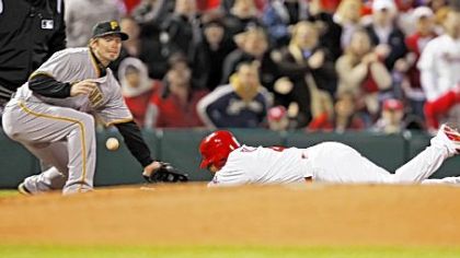 St. Louis' Yadier Molina dives into third base with a triple in the second inning as the ball caroms away from Pirates third baseman Andy LaRoche.