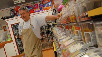 Doug Alpern, owner of Village Candy in Sewickley, with some of his candy bins.