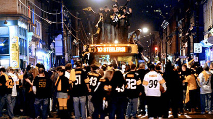 Fans celebrate on top of a Port Authority bus on Carson Street in the South Side during the half time of the Steelers' Super Bowl XLIII victory tonight.