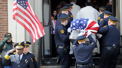 Pittsburgh Police Chief Nate Harper, front left, salutes as the flag-draped casket of Officer Paul J. Sciullo II is carried into St. Joseph Church in Bloomfield for his funeral yesterday.