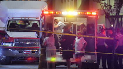Emergency workers tend to victims of last night's shooting.