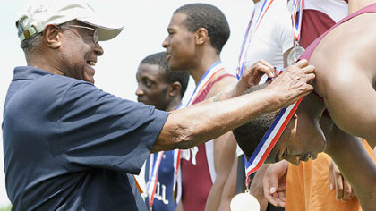 After winning the Class AAA 100-meter dash yesterday in Shippensburg, Pa., Peabody's Pierre Carr, right, receives his gold medal from Allderdice alum Herb Douglas. Douglas, 87, was the first athlete from the City League to win both the 100 and 200 in 1940. Carr repeated his feat yesterday.