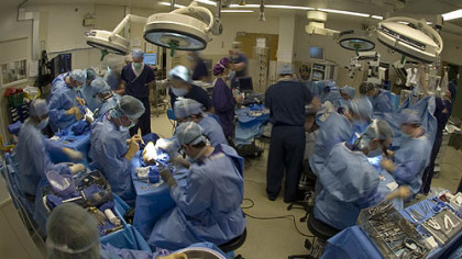 Surgeons perform the nation's first double hand transplant Monday at UPMC. Team in foreground is preparing one of the donor's arms and hands for attachment to the patient.