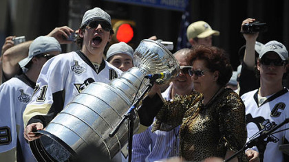 Evgeni Malkin cheers after his parents, Vladimir and Natalia, drank champagne from the Stanley Cup.
