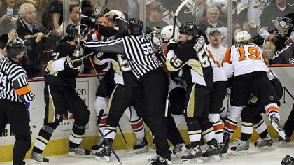 Referees separate Penguins and Flyers payers at the end of the first period.
