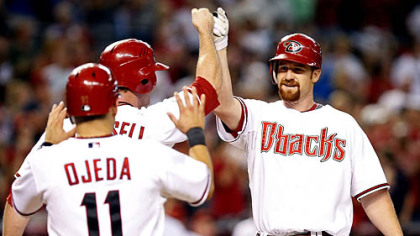 Diamondbacks first baseman Chad Tracy, right, gets high fives from first baseman Josh Whitesell, middle, and infielder Augie Ojeda after hitting a three-run home run in the seventh inning.