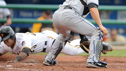 Pirates catcher Robinzon Diaz slides home as Mets catcher Omir Santos waits for a throw in the second inning yesterday.