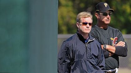 General manager Neal Huntington, left, and manager John Russell watch yesterday's workout at Pirate City. Pirates management picked up Russell's option for 2010 earlier in the day.