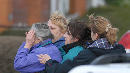 Family members of shooting suspect Richard Poplawski -- including women identified by a friend as his grandmother, far left, and mother, second from right -- comfort each other along Fairfield Street in Stanton Heights yesterday.