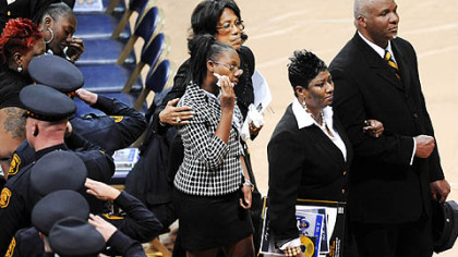 Marena Kelly, widow of Officer Eric G. Kelly, is escorted out of the Petersen Events Center after the memorial service.