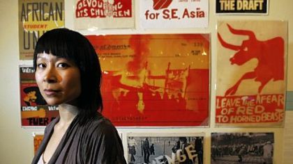 Astria Suparak, who became director of the Miller Gallery at Carnegie Mellon University last year, stands before some of the artwork in "Signs of Change: Social Movement Cultures 1960s to Now," an exhibition guest-curated by Dara Greenwald and Josh MacPhee that premiered at Exit Art, New York, and continues here through March 8.