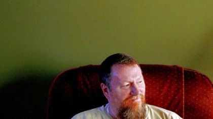 Jeff Kepner in the living room of his Augusta home underneath a copy of his and his wife's favorite painting, Michelangelo's "Creation of Adam."