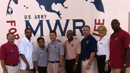 Pitt Coach Agnus Berenato and some of the  coaches she is with and a few soliders.