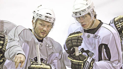 Sergei Gonchar, left, explains a drill to teammate Evgeni Malkin during hockey practice at Southpointe yesterday. The Penguins take on the Carolina Hurricanes in Game 1 of the Eastern Conference finals tonight at Mellon Arena.