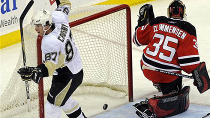 Sidney Crosby, left, celebrates after scoring a goal against New Jersey Devils goaltender Scott Clemmensen during the first period of last night's game.