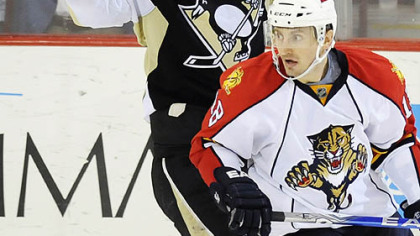 The Panthers' Ville Peltonen looks on as Sidney Crosby celebrates his tying goal in the third period.