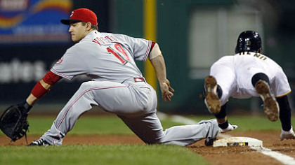 Pirates shortstop Ronny Cedeno dives for first base as Reds first baseman Joey Votto reaches for the throw from third baseman Scott Rolen in the second inning. Cedeno was safe as the ball got past Votto.