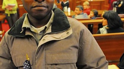 Omar Muya, the first Somali living in Pittsburgh to become a U.S. citizen,  received a miniature American flag at the end of the naturalization citizenship ceremony at the Federal Courthouse, Downtown.