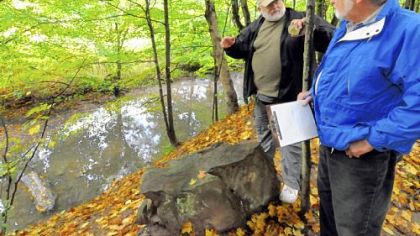 William Frankfort, president of the Peters Creek Historical Society, and Larry Gallant, right, the society's field investigator, speculate on the origins of a stone monolith along the Montour Trail in South Park.