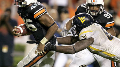 Auburn linebacker Craig Stevens, left, intercepts a pass and returns it for a touchdown past West Virginia offensive line Selvish Capers, right, in last night's game.