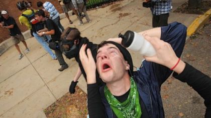 After suffering the effects of tear gas sprayed by the police, a man has a solution poured into his eyes during an unlawful protest march that began at Arsenal Park in Lawrenceville yesterday.