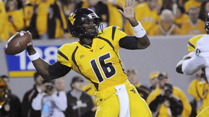 West Virginia quarterback Jarrett Brown runs past Cincinnati defensive lineman Dan Giordano for a first-quarter touchdown last night in Cincinnati.