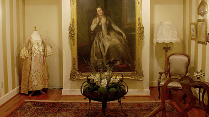 The parlor displays a photo of a family relative, a countess and a restored gown that she wore.