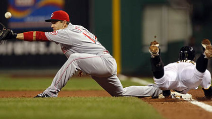 Pirates shortstop Ronny Cedeno dives for first base as Reds first baseman Joey Votto reaches for the throw from third baseman Scott Rolen in the second inning. Cedeno was safe as the ball got past Votto.