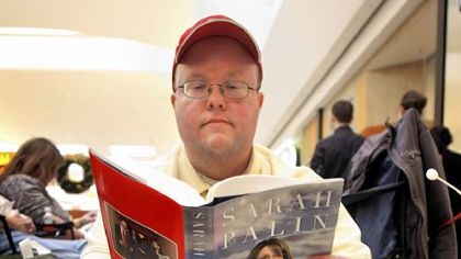 Jeremy Hahn of Traverse City, Mich., reads as he and others wait in line yesterday for the signing of former Alaska Gov. Sarah Palin's new book, "Going Rogue," at a Barnes & Noble bookstore in Grand Rapids, the first stop of her book signing tour.