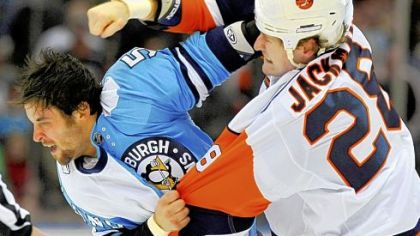 The Islanders' Tim Jackman and the Penguins' Deryk Engelland fight in the first period yesterday in Uniondale, N.Y.  Both players were given penalties.