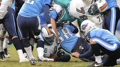 Tennessee Titans place kicker Rob Bironas makes a 46-yard field-goal attempt in overtime to beat the Miami Dolphins, 27-24, yesterday. 
Trying to block the kick are Dolphin defenders Phillip Merling (97), Yeremiah Bell (37) and Tony McDaniel (78).