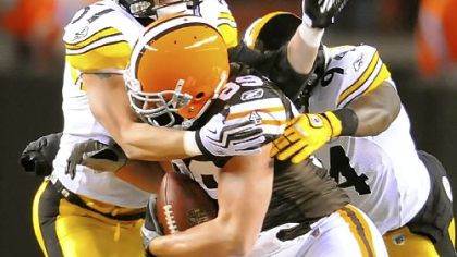 Browns tight end Evan Moore fights off tackle attempts by Steelers linebackers James Farrior and Lawrence Timmons last night at Cleveland Browns Stadium.