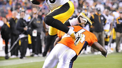 Steelers wide receiver Hines Ward leaps over  Broncos cornerback Champ Bailey into the end zone for a touchdown in the fourth quarter of last night's game at Invesco Field in Denver.