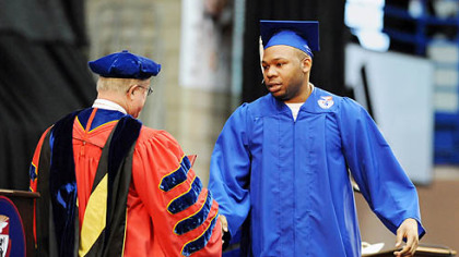 Sam Ashaolu accepts his diploma from Duquesne University President Charles Dougherty.