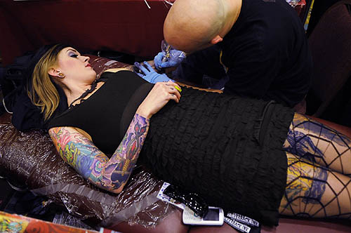 She is wearing spidernetting stockings over her tattooed legs