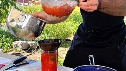 Jamie Moore, Eat'n Park's director of sourcing and sustainability, demonstrates canning tomatoes at the Braddock Community Garden last month.