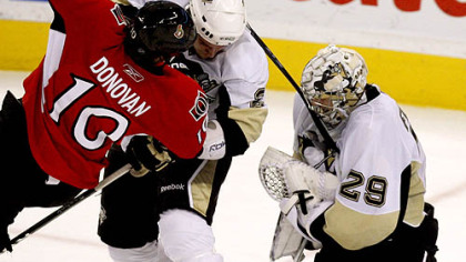Senators forward Shean Donovan is checked by Penguins defenseman Nathan Guenin as Penguins goaltender Marc-Andre Fleury (29) holds the puck during the second period.