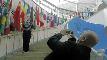 Chinese G-20 delegate Huiyu Zheng is photographed with his country's flag on the steps at Phipps Conservatory by a colleague, Omar Bouzid of Morocco. There was a flurry of activity at Phipps yesterday as it prepared to host events for the summit.